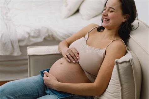 Attractive Pregnant Woman Is Sitting In Bed And Holding Her Belly Last