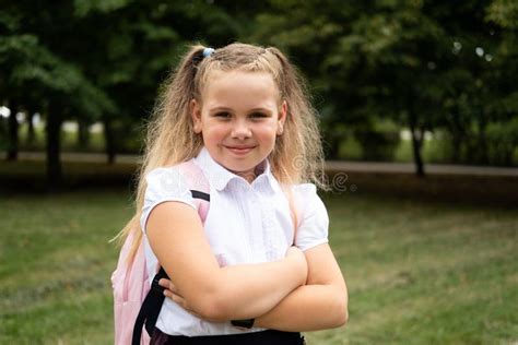 Lächelnd Blonde Schülerin In Der Schuluniform Mit Rosa Rucksack Geht Zur Schule Im Freien