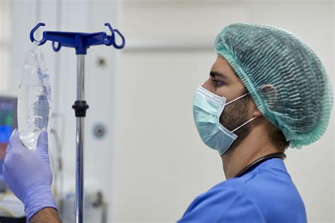 One Male Nurse Adjusting The Iv Drip In The Operation Room Stock Photo