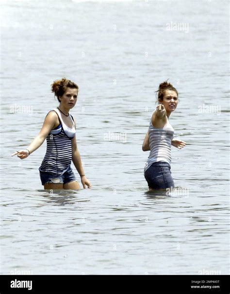 miley cyrus frolics in the surf with friends castmates while filming her latest hannah montana