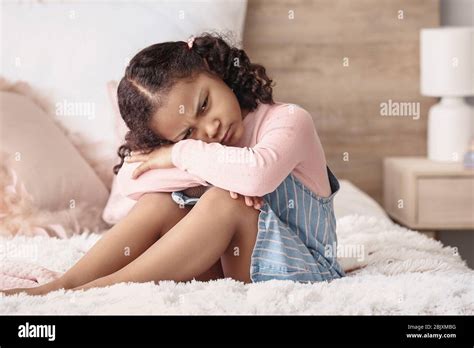 Sad Little African American Girl Sitting On Bed Stock Photo Alamy
