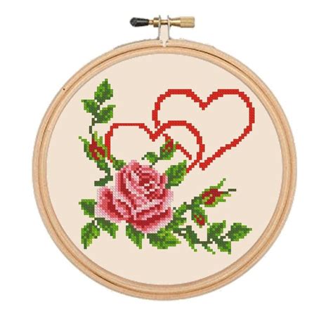 A Cross Stitch Rose With Two Hearts On It