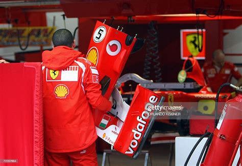 A Mechanic Of Ferrari F1 Team Carries The Front Spoiler Of German