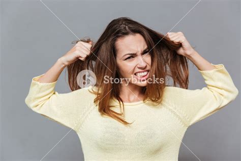 Portrait Of A Fustrated Angry Woman Pulling Her Hair Out Isolated On