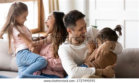 Excited Parents Having Fun With Two Little Daughters At Home Cute