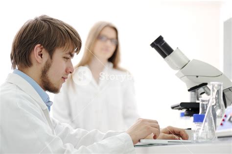 Science Team Working With Microscopes In A Laboratory Royalty Free