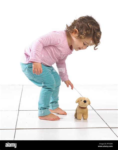 Young Girl Bending Over Towards Toy Dog 2 Years Stock Photo Alamy