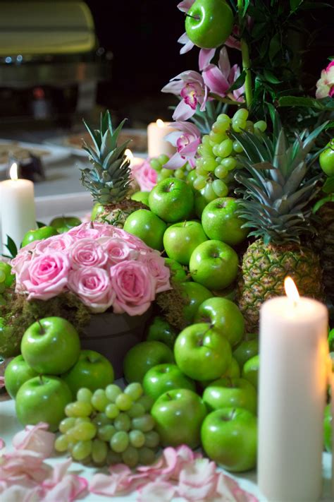 A Table Topped With Lots Of Green Apples Covered In Flowers And Fruit
