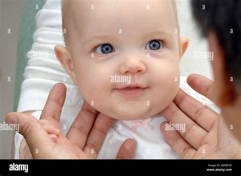 A Gp Checks A Babys Neck For Swollen Glandsmodel Released Stock Photo