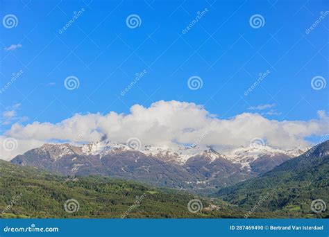 A Scenics View Of A Green Mountain Valley With Snowy Rocky Mountain