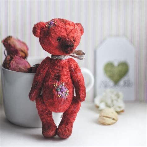 A Small Red Teddy Bear Sitting In A Cup