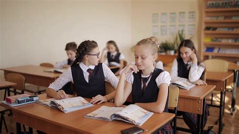 Students In School At Their Desks Listen And Answer The Teachers
