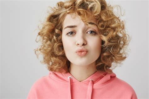 Free Photo Cute Shy Curly Haired Girl Folding Lips Trying To Kiss