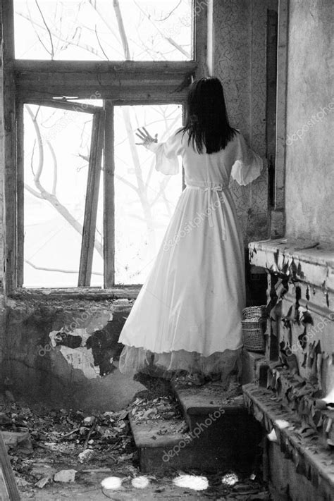 sad mood in an old abandoned house with girl wearing an old fashioned wedding dress with