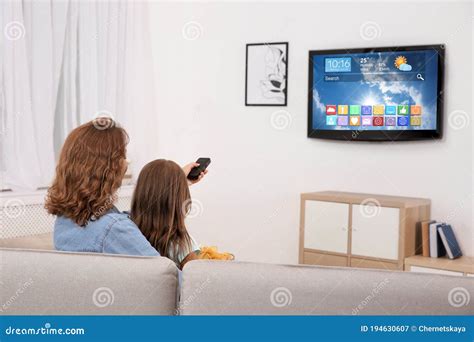 Madre E Hija Viendo La Televisión Inteligente En La Habitación Imagen