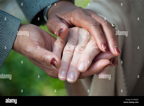 Young African American Hands Holding Older Caucasian Hand Stock Photo