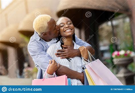 Hugs On Walk At Shopping Cheerful African American Guy Kissing