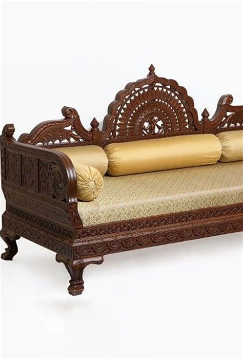 An Ornate Wooden Daybed With Pillows On Its Sides And Back Rests