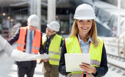 Portrait Smiling Female Engineer With Clipboard At Construction Site