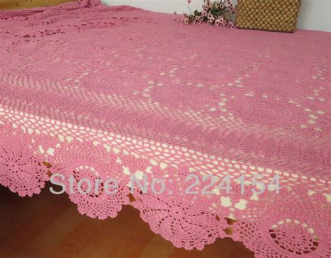 A Pink Crocheted Bedspread On A Wooden Bed