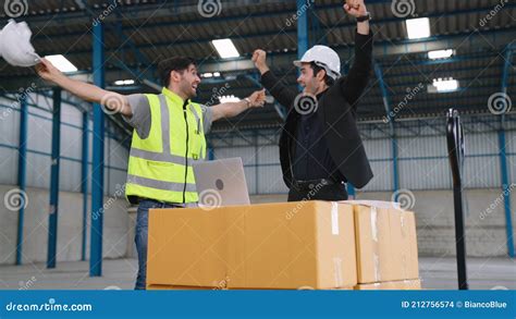 Two Factory Worker Celebrate Success Together In The Factory Stock