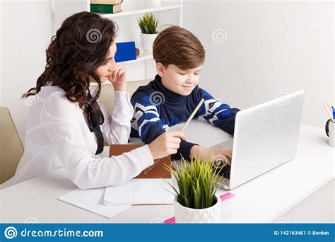 Doing Homework On The Laptop Child Doing Homework And His Teacher