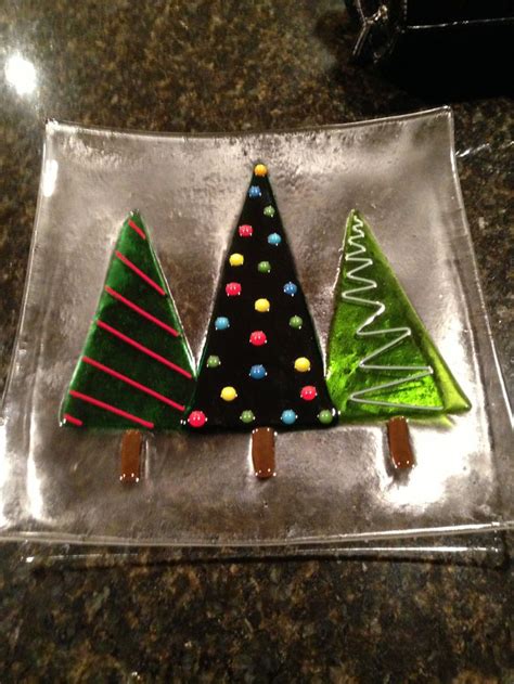 Three Decorated Christmas Trees Sitting On Top Of A Glass Plate