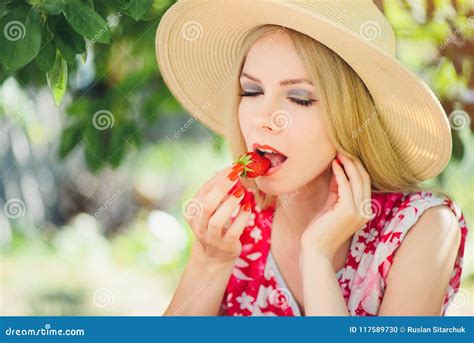 Young Blond Woman Eating Strawberries In The Garden Summer Sunny Day Warm Summer Toning Image