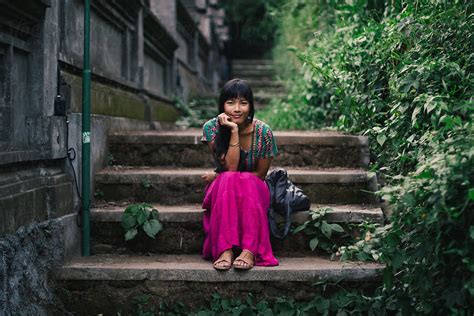 Beautiful Young Asian Woman In Pink Skirt Sitting By The Temple Stone