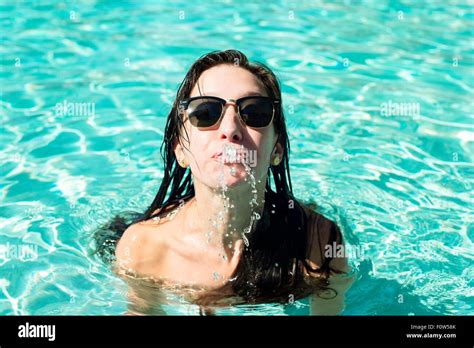 porträt der jungen frau im schwimmbad wasser aus mund spritzen stockfotografie alamy