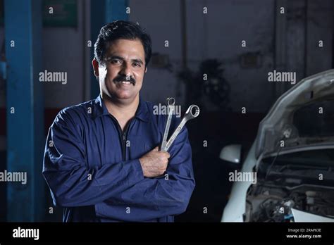 Portrait Of A Happy Car Mechanic In Moustache Standing Beside Car In