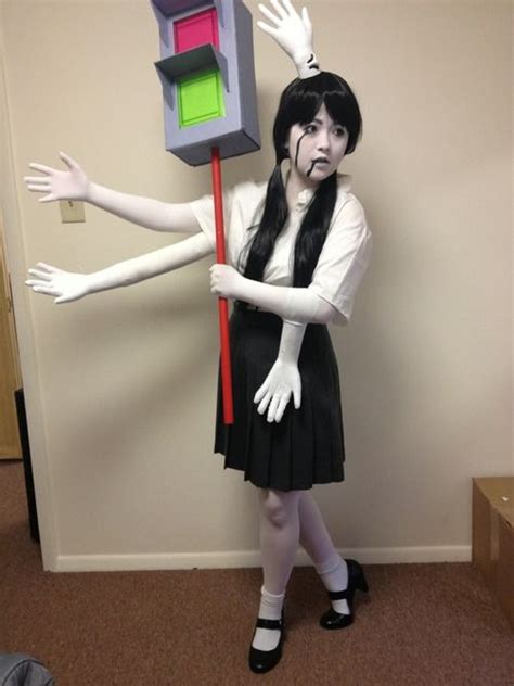 A Woman Dressed Up As An Evil Queen Holding A Cube With Her Arms And Legs