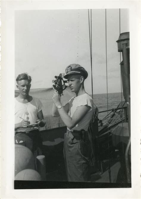 An Officer Uses A Sextant While A Sailor Writes Down Data In The