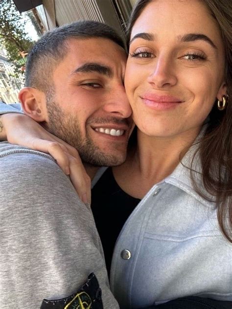 A Man And Woman Are Smiling For The Camera While They Pose For A Selfie