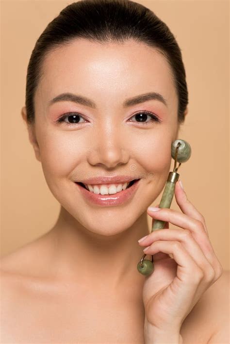 Belle Jeune Fille Asiatique Nue Souriante Faisant Un Massage Du Visage Avec Un Rouleau De Jade