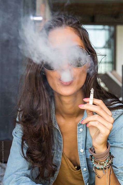 Beautiful Tanned Girl Blowing Cigarette Smoke Into The Camera By Jovo
