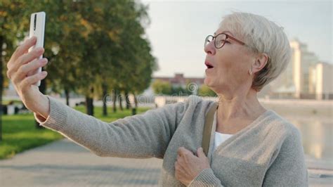 Beautiful Senior Lady Taking Selfie With Smart Phone Camera Posing At