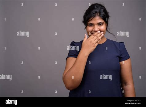Young Overweight Beautiful Indian Woman Against Gray Background Stock
