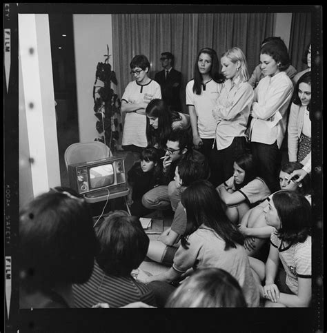 Group Of Women And A Man Gathered Around A Tv Most Likely Broadcasting