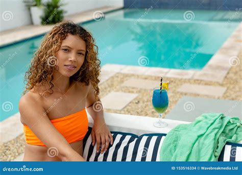Woman In Bikini Relaxing Near Swimming Pool In The Backyard At Home