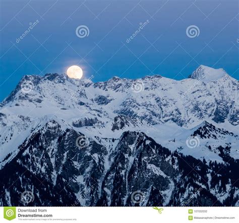 Full Moon Rising Over Winter Landscape And Mountains Stock