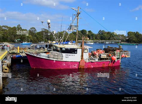 Fishing Boat Tied Up At Risby Cove Pier At Strahan On West Coast Of Tasmania Australia Stock