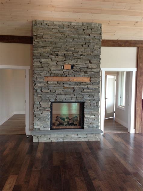 Stone See Through Fire Place With Tv Hanging Above Looking From The