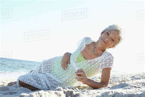 Senior Woman Laying On Tropical Beach Stock Photo Dissolve