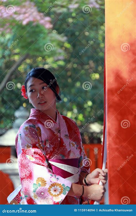 japanese girl in kimono dress stand and catch fabric rope to ringing the bell for bless at
