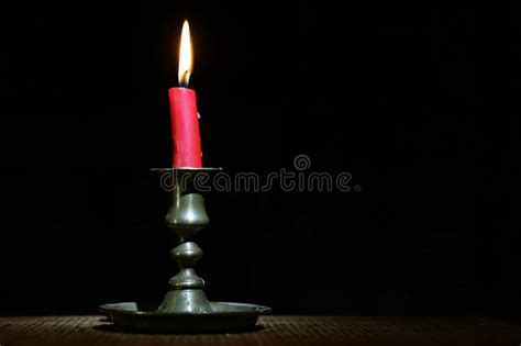 Burning Old Candle Vintage Bronze Candlestick On Black Wooden
