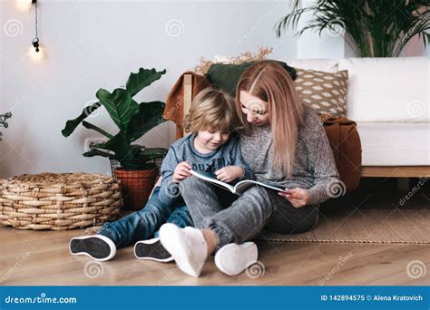 mother and son sitting and reading book together at home stock image image of care education