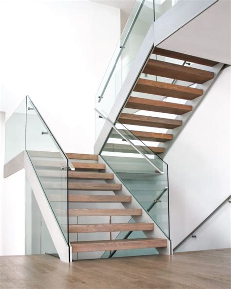 Placing the front stairway to the side of the entry enables guests standing at the front door of this home to see through to the rest of the first level. mrail Modern Stairs | Two Side Stringer Stairs