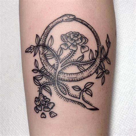A snake curling in a ring biting itself by the tail. Ouroboros Tattoo: The Symbol Of Eternity And Continuity