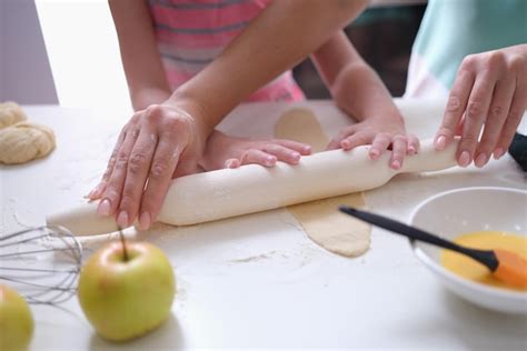 Premium Photo Mom And Daughter Roll Out The Dough With Rolling Pin In